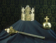 The funerary crown, orb and sceptre of Ottokar II of Bohemia on a dark blue cloth: an open gilt crown with a fleur-de-lis and small crosses, a plain orb topped by a cross, and a short sceptre ending in a finial of leaves