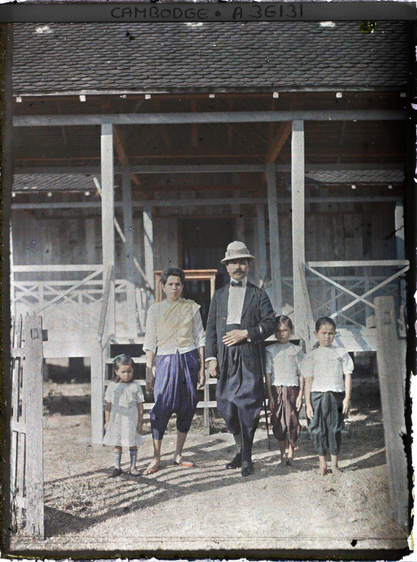 Autochrome of Cambodian official and family wearing mix of traditional sampot and Western dress
